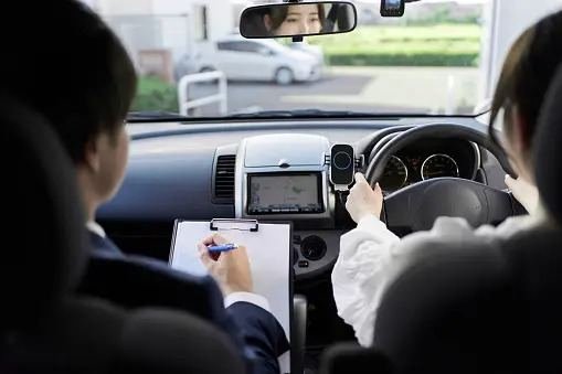 Instructor taking notes during a driving lesson